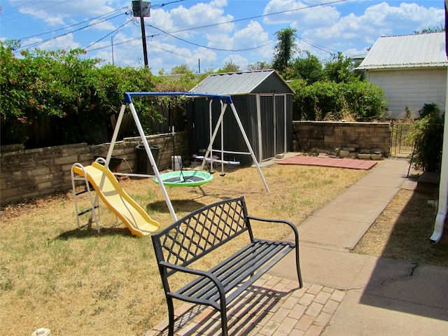 view of yard featuring a shed, a patio, and a playground