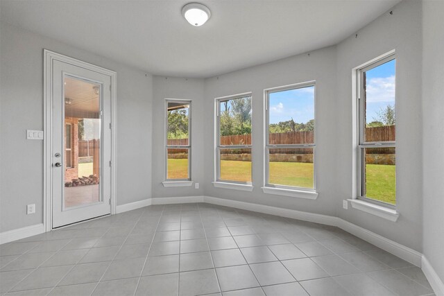 tiled empty room featuring plenty of natural light