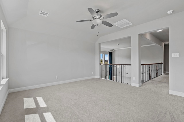 carpeted spare room featuring lofted ceiling and ceiling fan