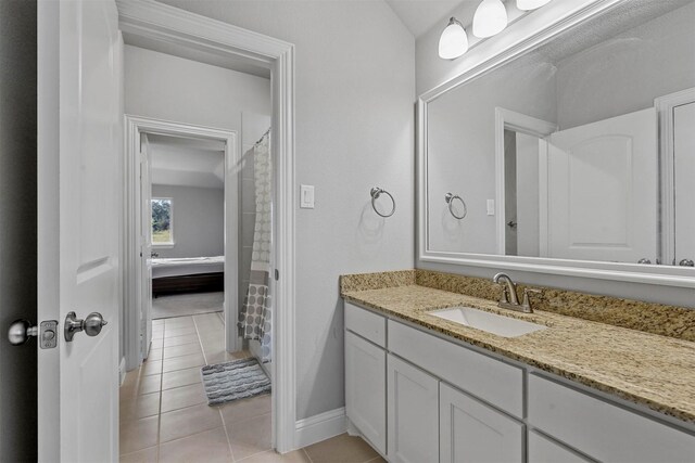 bathroom with tile patterned floors, walk in shower, and vanity