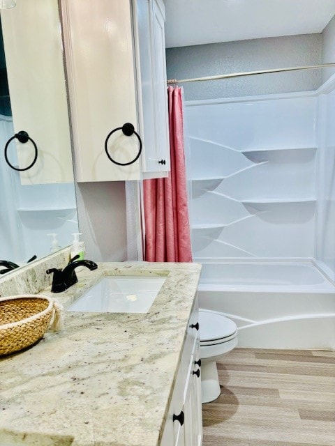 full bathroom featuring vanity, toilet, wood-type flooring, and shower / bathtub combination with curtain