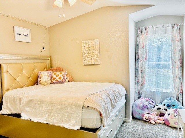 carpeted bedroom with ceiling fan and vaulted ceiling