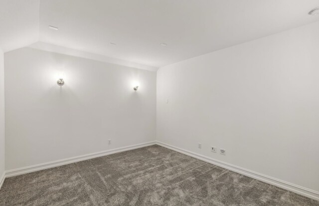 unfurnished room featuring carpet and lofted ceiling