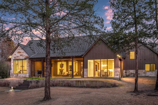 back house at dusk featuring a porch