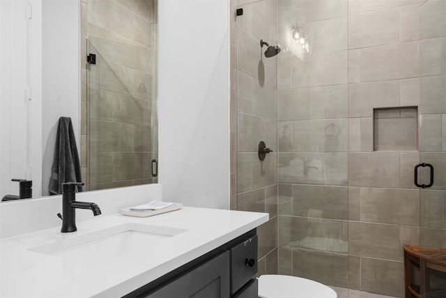 bathroom with vanity, toilet, and an enclosed shower