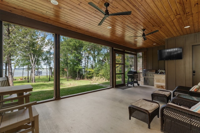 sunroom / solarium featuring wooden ceiling, a water view, and ceiling fan