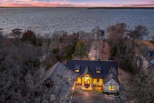 aerial view at dusk featuring a water view