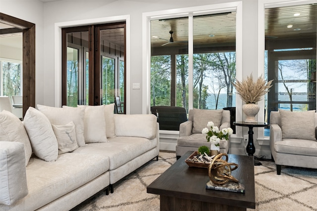 living room featuring ceiling fan and a water view