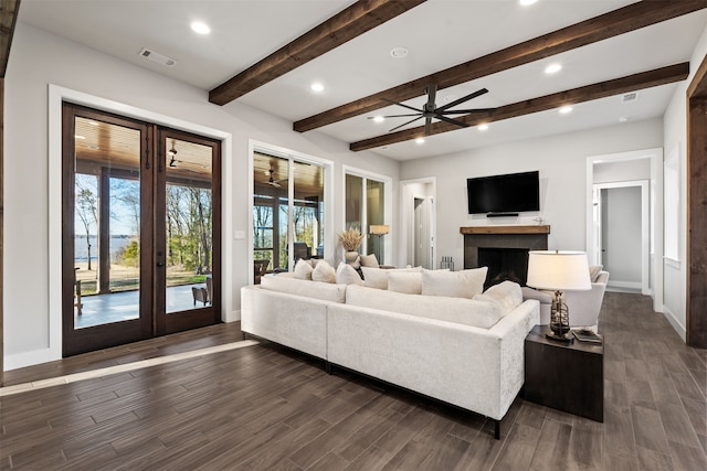 living room with french doors, ceiling fan, beamed ceiling, and dark wood-type flooring