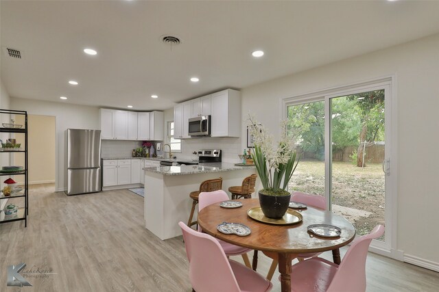 dining space with sink and light hardwood / wood-style floors