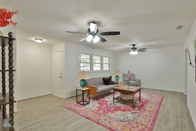 living room with light hardwood / wood-style flooring and ceiling fan