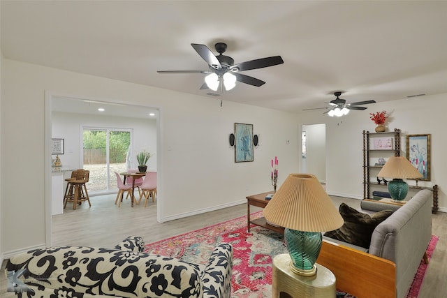 living room with light wood-type flooring and ceiling fan