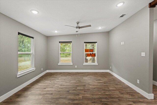 unfurnished room with dark wood-type flooring, ceiling fan, and a healthy amount of sunlight