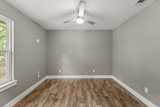 spare room featuring ceiling fan, plenty of natural light, and dark hardwood / wood-style floors