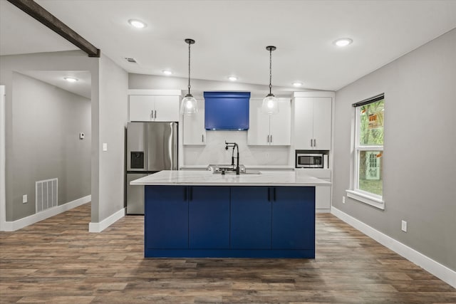 kitchen featuring a kitchen island with sink, appliances with stainless steel finishes, lofted ceiling, and dark hardwood / wood-style flooring