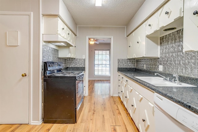 kitchen featuring black range with electric cooktop, white dishwasher, light wood-style flooring, a sink, and white cabinetry