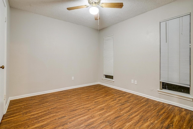 spare room with a textured ceiling, wood finished floors, a ceiling fan, and baseboards