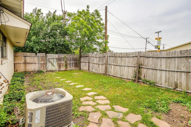 view of yard with central air condition unit and a fenced backyard