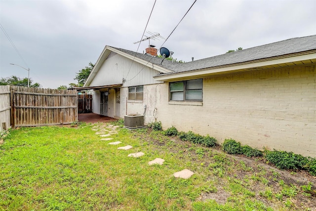 view of yard featuring central AC unit and fence