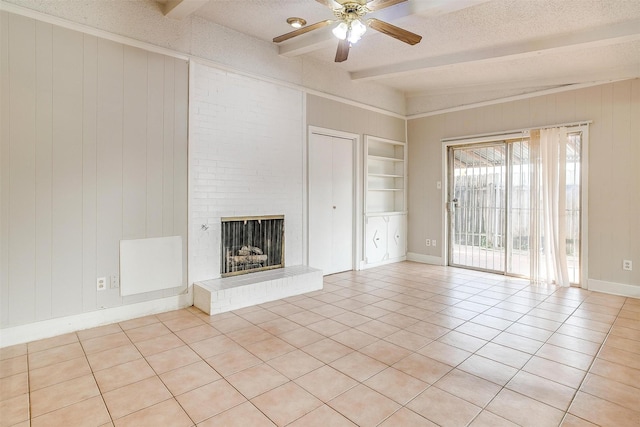 unfurnished living room featuring built in features, beam ceiling, a fireplace, light tile patterned floors, and a textured ceiling