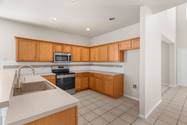 kitchen with light tile patterned floors, stainless steel appliances, sink, and decorative backsplash