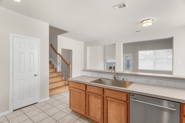 kitchen with light tile patterned floors, sink, and stainless steel dishwasher