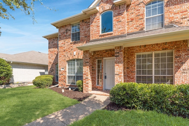 view of front facade with a front lawn and brick siding