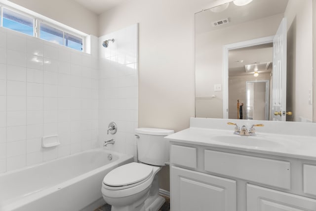 full bathroom featuring tiled shower / bath combo, vanity, and toilet