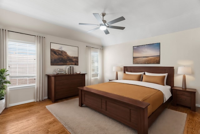 bedroom with ceiling fan, vaulted ceiling, and light hardwood / wood-style flooring