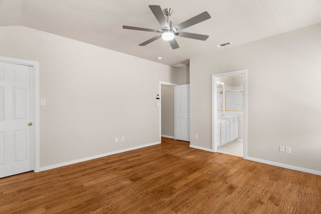 unfurnished bedroom with lofted ceiling, ceiling fan, ensuite bathroom, and light hardwood / wood-style floors