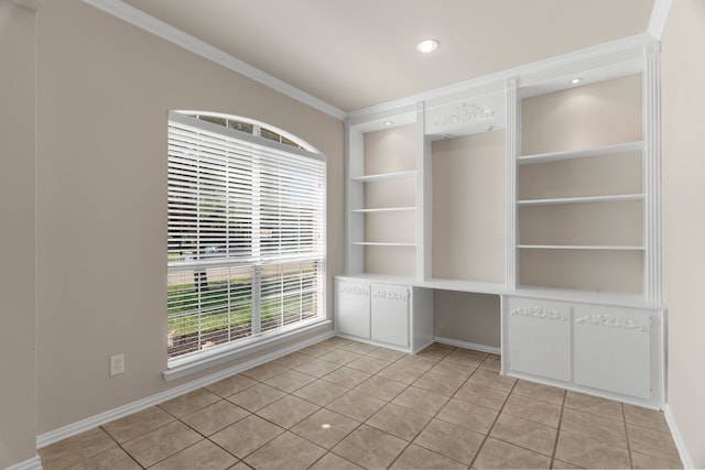 tiled spare room with built in features and crown molding