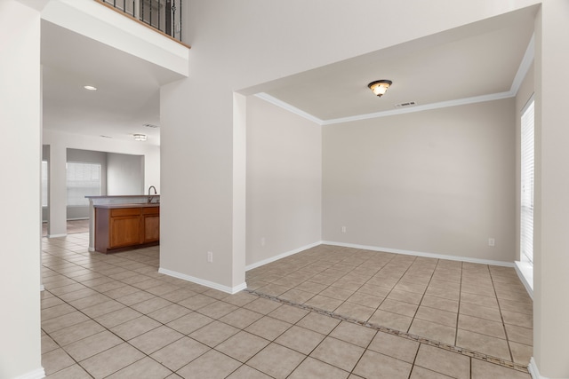 tiled spare room with crown molding and sink