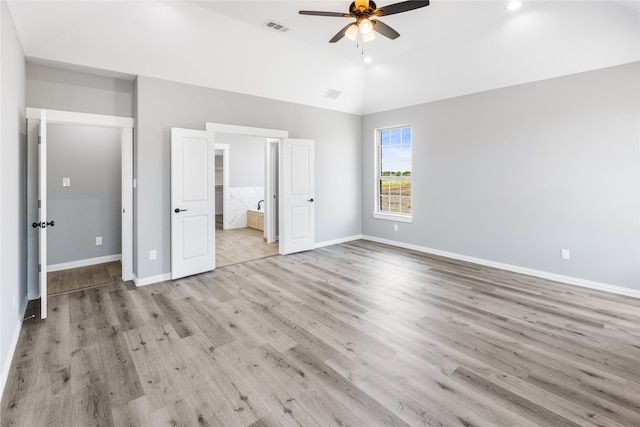 unfurnished bedroom featuring lofted ceiling, ceiling fan, light hardwood / wood-style floors, and ensuite bath