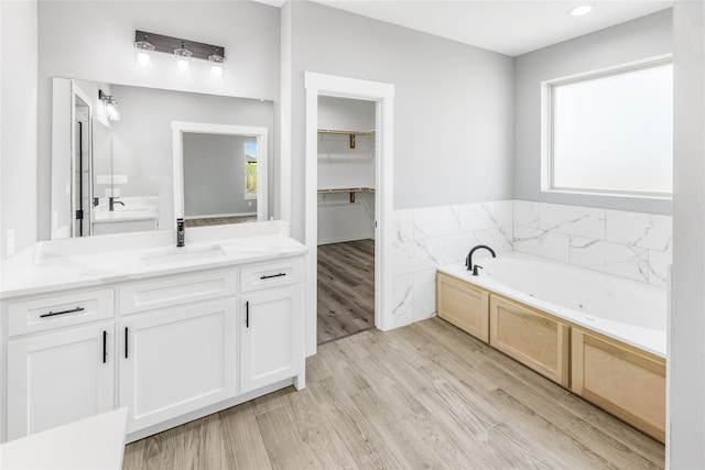 bathroom with hardwood / wood-style floors, a bathing tub, and vanity