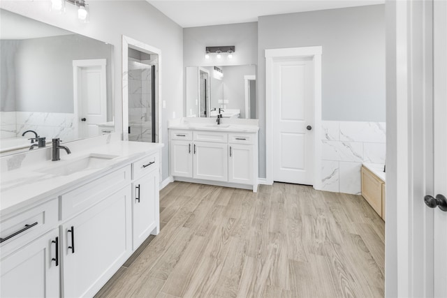 bathroom with wood-type flooring, shower with separate bathtub, and vanity