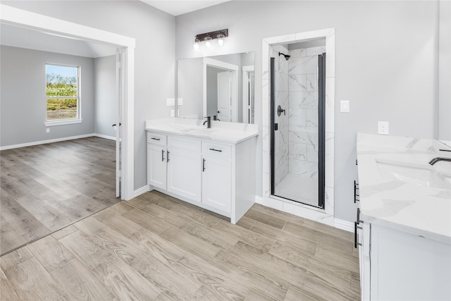 bathroom with a shower with door, vanity, and hardwood / wood-style flooring