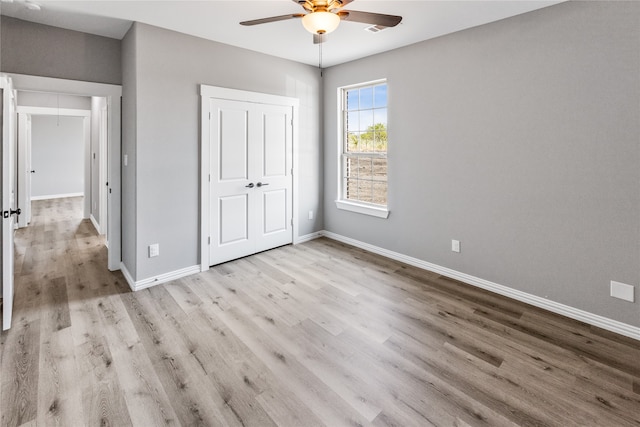 unfurnished bedroom with ceiling fan and light hardwood / wood-style floors