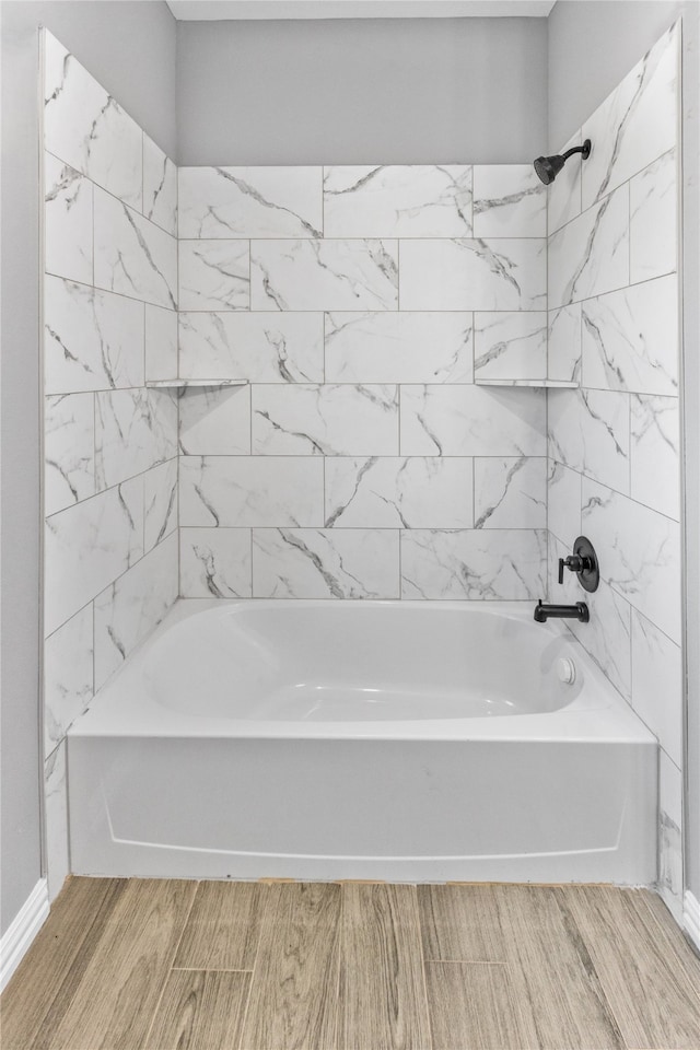 bathroom with tiled shower / bath combo and wood-type flooring