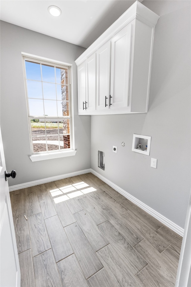 laundry area featuring cabinets, hookup for an electric dryer, and light hardwood / wood-style floors