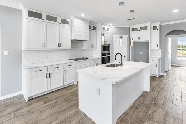 kitchen featuring white cabinetry, backsplash, sink, and decorative light fixtures