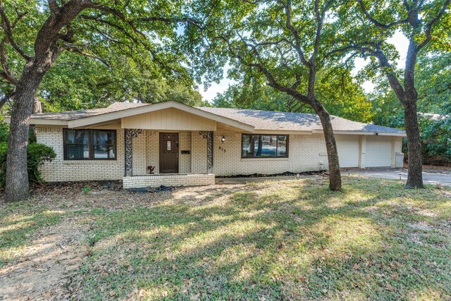 ranch-style house with a front yard, a garage, and covered porch