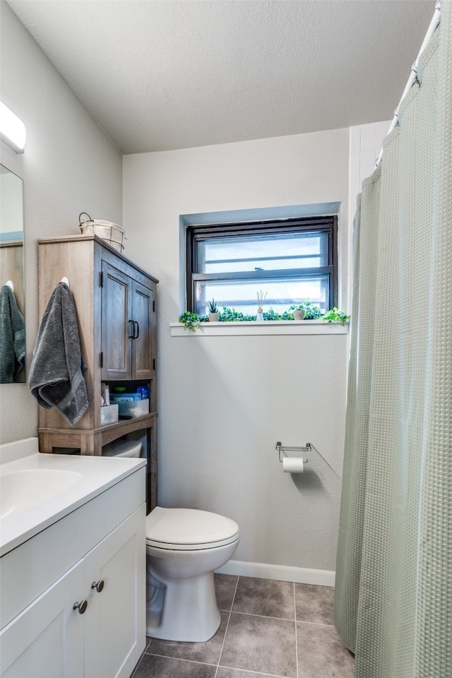 bathroom with tile patterned floors, a textured ceiling, vanity, and toilet