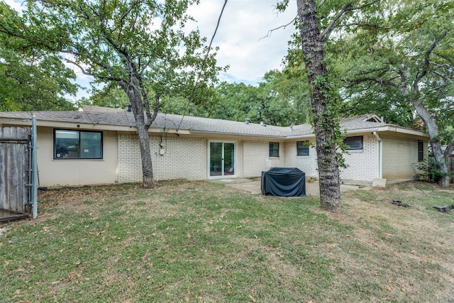 back of property with a lawn and a patio