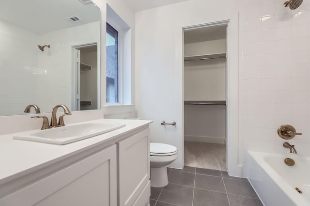 full bathroom featuring tiled shower / bath, tile patterned floors, toilet, and vanity