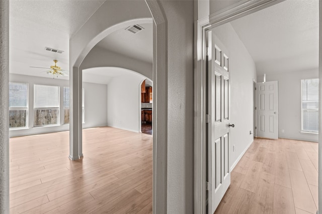 hallway featuring a textured ceiling and light hardwood / wood-style flooring