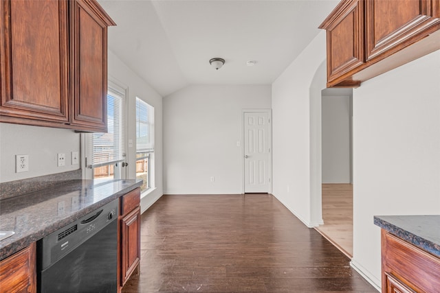 kitchen featuring lofted ceiling, dishwasher, dark hardwood / wood-style flooring, and dark stone counters