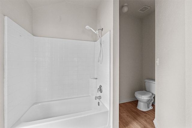 bathroom featuring toilet, wood-type flooring, and shower / tub combination