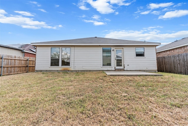 rear view of house with a patio area and a lawn