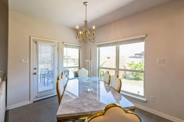 dining area with an inviting chandelier and dark tile patterned flooring