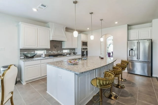 kitchen with stainless steel appliances, light stone countertops, and white cabinets